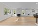 Open-concept living room with fireplace, windows, built-ins, and hardwood floors, seamlessly connecting to the kitchen at 811 Maple Berry Ln # 101, Raleigh, NC 27607