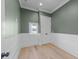 Stylish bedroom with green walls, white wainscoting, and a large window allowing natural light at 811 Maple Berry Ln # 102, Raleigh, NC 27607