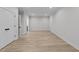 This bright bedroom features light hardwood floors, white walls, and a view into the ensuite at 811 Maple Berry Ln # 102, Raleigh, NC 27607