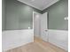 Stylish bedroom with green walls, white wainscoting, and a modern light wood floor at 811 Maple Berry Ln # 102, Raleigh, NC 27607