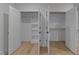 Bright closets featuring white walls, built in shelving, closet rods, and view into the bedroom at 811 Maple Berry Ln # 102, Raleigh, NC 27607