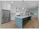 Modern kitchen with white cabinets, stainless steel appliances, and stylish blue island at 811 Maple Berry Ln # 102, Raleigh, NC 27607