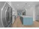Modern kitchen with white cabinetry, stainless steel appliances, and a center island with a contrasting blue base at 811 Maple Berry Ln # 102, Raleigh, NC 27607