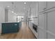 Modern kitchen featuring white cabinets, stainless steel appliances, a blue island, and light hardwood floors at 811 Maple Berry Ln # 102, Raleigh, NC 27607