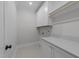 Bright laundry room features white cabinetry, modern countertop, and tile floors at 811 Maple Berry Ln # 102, Raleigh, NC 27607
