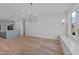 Spacious living room with hardwood floors, modern light fixture, and abundant natural light at 811 Maple Berry Ln # 102, Raleigh, NC 27607