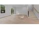 Bright living room featuring hardwood floors, neutral paint, sliding glass door, and a staircase at 811 Maple Berry Ln # 102, Raleigh, NC 27607