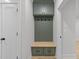 Cozy mudroom with a built-in bench, hooks, upper cabinets, and view into the hallway at 811 Maple Berry Ln # 102, Raleigh, NC 27607
