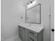 Modern bathroom features a vanity with sage green cabinets and a white countertop, plus a large framed mirror at 811 Maple Berry Ln # 103, Raleigh, NC 27607