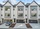 Modern townhome featuring a stylish white exterior with black accents, garages, and manicured landscaping at 811 Maple Berry Ln # 103, Raleigh, NC 27607
