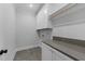 Bright laundry room with gray tile flooring, quartz countertops, and white cabinets for ample storage at 811 Maple Berry Ln # 103, Raleigh, NC 27607