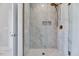 Elegant shower with marble tiles, glass enclosure, and gold fixtures at 811 Maple Berry Ln # 104, Raleigh, NC 27607