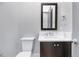 Stylish half bathroom features modern fixtures, dark wood vanity, and a framed mirror at 811 Maple Berry Ln # 105, Raleigh, NC 27607