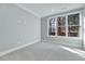Bright bedroom featuring neutral carpet, fresh paint, a large window and white trim at 811 Maple Berry Ln # 105, Raleigh, NC 27607