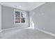 Bright bedroom featuring neutral carpet, fresh paint, a large window and white trim at 811 Maple Berry Ln # 105, Raleigh, NC 27607