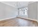 Spacious bedroom with hardwood floors, a window seat and a modern chandelier at 811 Maple Berry Ln # 105, Raleigh, NC 27607