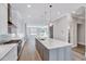 A modern kitchen boasts a large island, stainless steel appliances, and sleek white cabinets, enhancing its functionality at 811 Maple Berry Ln # 105, Raleigh, NC 27607
