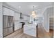 Open kitchen with stainless steel appliances, waterfall island, and hardwood floors at 811 Maple Berry Ln # 106, Raleigh, NC 27607