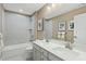 Bright bathroom featuring a double vanity, bathtub with tiled surround, and modern fixtures at 8841 Tartan Clan Dr, Willow Springs, NC 27592