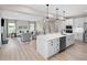 Open concept kitchen featuring an island, white cabinets, stainless steel appliances, and views of the living room at 8841 Tartan Clan Dr, Willow Springs, NC 27592