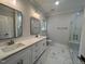 Bathroom with double sinks, marble countertops, and a glass-enclosed shower at 2710 - A Mansfield Ave, Durham, NC 27703