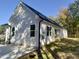 Exterior view of a modern white home with a dark roof and verdant backyard at 2710 - A Mansfield Ave, Durham, NC 27703