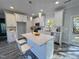 Bright white kitchen featuring a large island, stainless steel appliances, and modern pendant lighting at 2710 - A Mansfield Ave, Durham, NC 27703