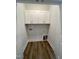 Well-lit laundry room with white cabinets and wood-look flooring at 2710 - A Mansfield Ave, Durham, NC 27703