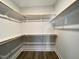 Spacious walk-in closet with wooden clothes rods, shelves, and neutral paint at 2710 - A Mansfield Ave, Durham, NC 27703
