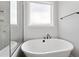 Contemporary bathroom featuring a stand-alone tub and a frosted window for privacy at 55 Firefly Ln, Louisburg, NC 27549