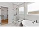 Bright bathroom featuring a glass-enclosed shower, a soaking tub, and a walk-in closet at 55 Firefly Ln, Louisburg, NC 27549