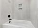 Modern bathtub with black hardware and tiled surround at 55 Firefly Ln, Louisburg, NC 27549