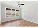 Bright bedroom with beautiful hardwood floors, ceiling fan, and large windows offering backyard views at 55 Firefly Ln, Louisburg, NC 27549