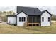Rear exterior of a white home with a dark roof and a screened-in porch with wooden stairs at 55 Firefly Ln, Louisburg, NC 27549