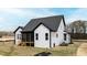 Exterior rear view of a modern farmhouse-style home with a screened porch and manicured lawn at 55 Firefly Ln, Louisburg, NC 27549