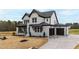 New construction home with white brick, black trim, a two-car garage and concrete driveway at 55 Firefly Ln, Louisburg, NC 27549