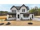 New construction home with white brick, black trim, covered porch and tasteful landscaping at 55 Firefly Ln, Louisburg, NC 27549