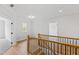 Bright hallway with wood railing, natural light, and access to carpeted and hardwood floor bedrooms at 55 Firefly Ln, Louisburg, NC 27549