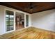 Covered porch with wooden flooring, ceiling fan, and sliding door to the home's interior at 55 Firefly Ln, Louisburg, NC 27549