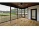 Spacious screened-in porch featuring wooden flooring, a ceiling fan, and an exterior view at 55 Firefly Ln, Louisburg, NC 27549