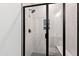 Contemporary shower stall with glass door, white tiling, black fixtures, and built-in shower bench at 55 Firefly Ln, Louisburg, NC 27549