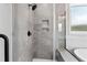 Modern shower featuring a built-in shampoo nook and gray tiled walls at 55 Firefly Ln, Louisburg, NC 27549