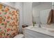 Bright bathroom with a white vanity, light countertops, and a patterned shower curtain at 628 Dorado Rd, Wendell, NC 27591