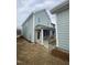 View of a light green home with a covered patio with white columns and black metal railing at 9212 Leaning Post Rd # 448, Wake Forest, NC 27587