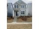 Charming two-story home with light green siding, black shutters, and a welcoming front porch and landscaped yard at 9212 Leaning Post Rd # 448, Wake Forest, NC 27587