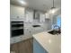 Modern kitchen featuring white cabinets, stainless steel appliances, quartz countertops, and a kitchen island at 9212 Leaning Post Rd # 448, Wake Forest, NC 27587