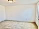 A bright bedroom featuring neutral-toned walls and carpet and a large window at 140 Token House Rd, Durham, NC 27703