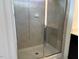 Close-up of a glass enclosed tiled shower, featuring a built-in bench and soap holder at 140 Token House Rd, Durham, NC 27703