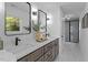This bathroom has a double sink vanity, modern fixtures, and walk-in shower with black trim at 215 E Cabarrus St, Raleigh, NC 27601