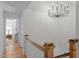 Well-lit hallway with wooden railings and modern chandelier at 215 E Cabarrus St, Raleigh, NC 27601